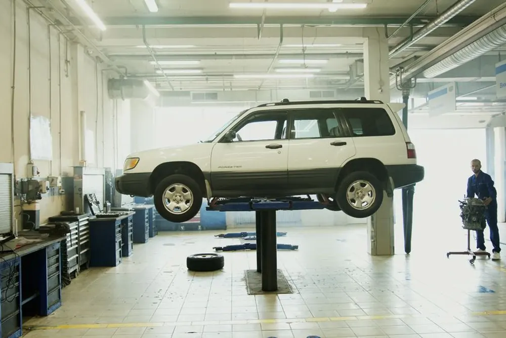 A vehicle raised on a lift in a service workshop