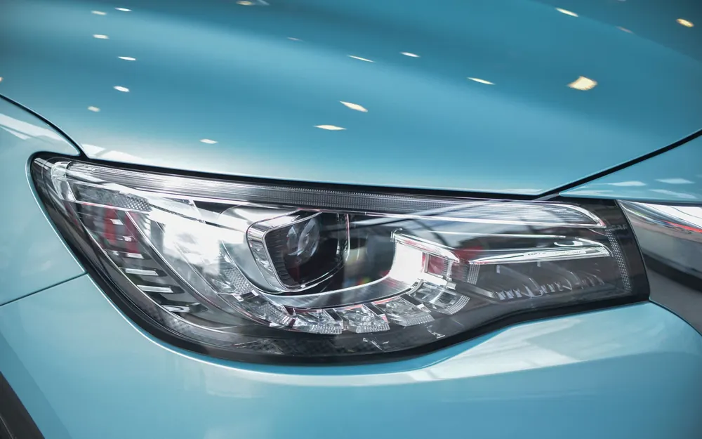 The headlight of a clean modern car in daylight