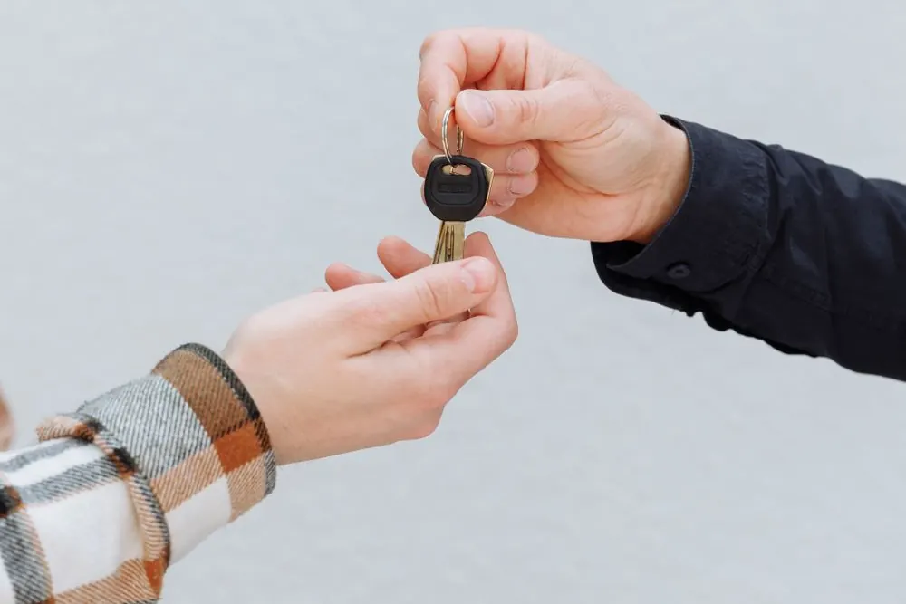 A car key passed from one hand to another