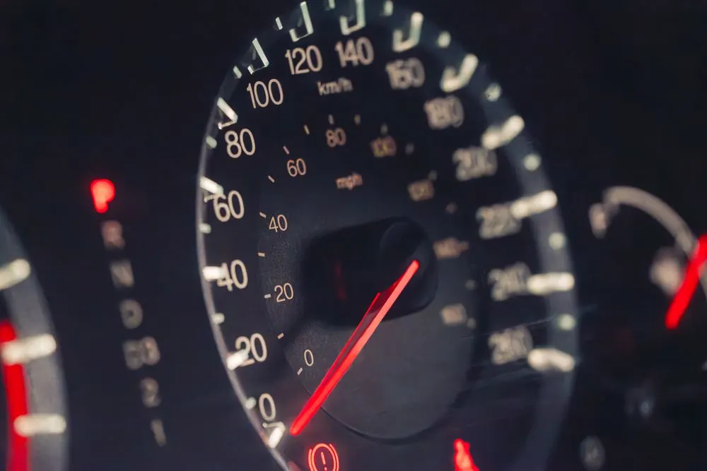 A car speedometer lit at night