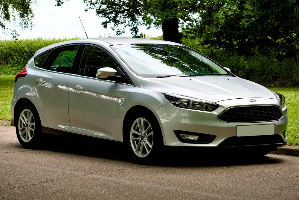 A single clean silver hatchback parked at the roadside