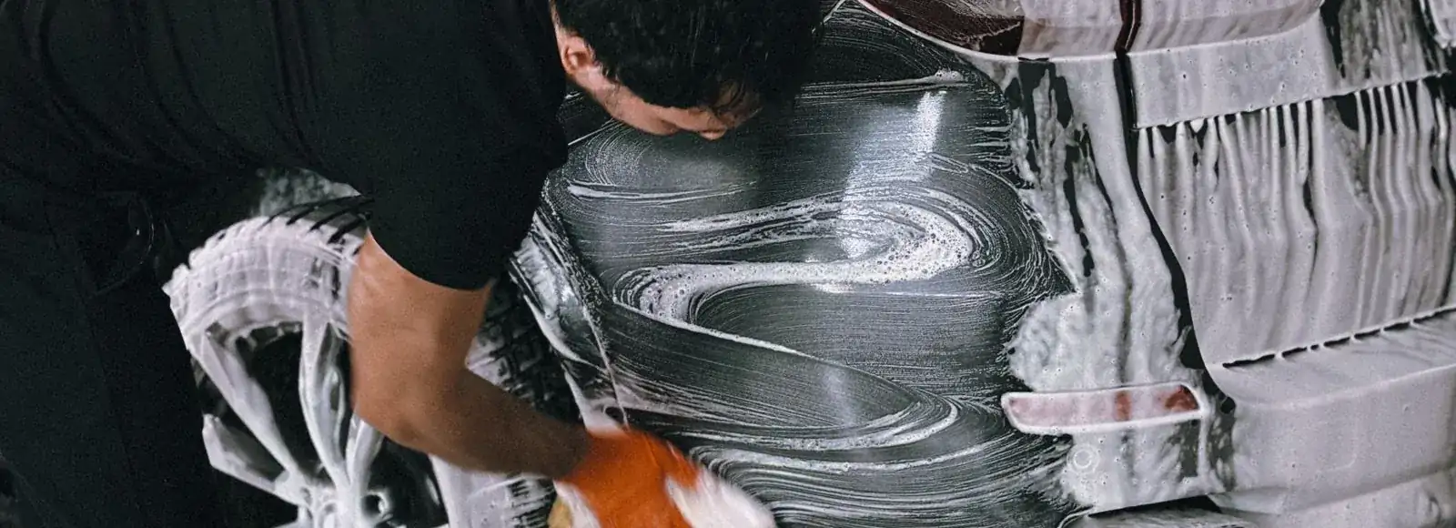 A car being washed by hand before it goes back out on the floor