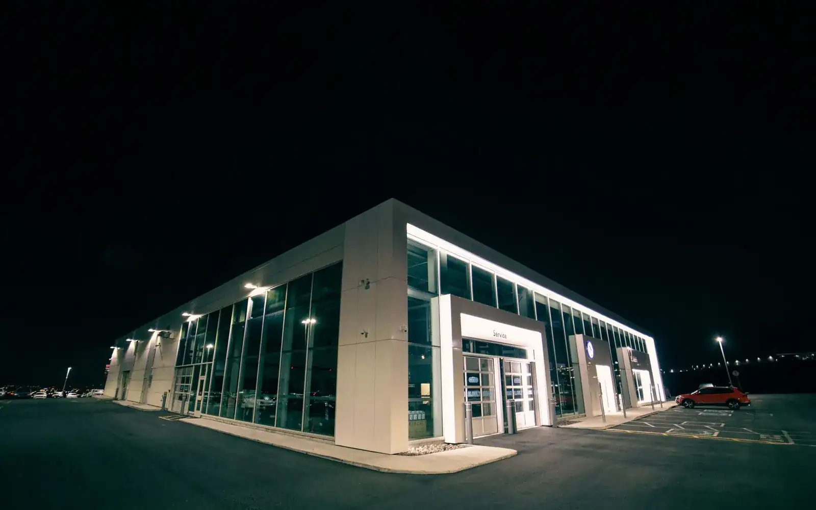 A car dealership building lit up at night