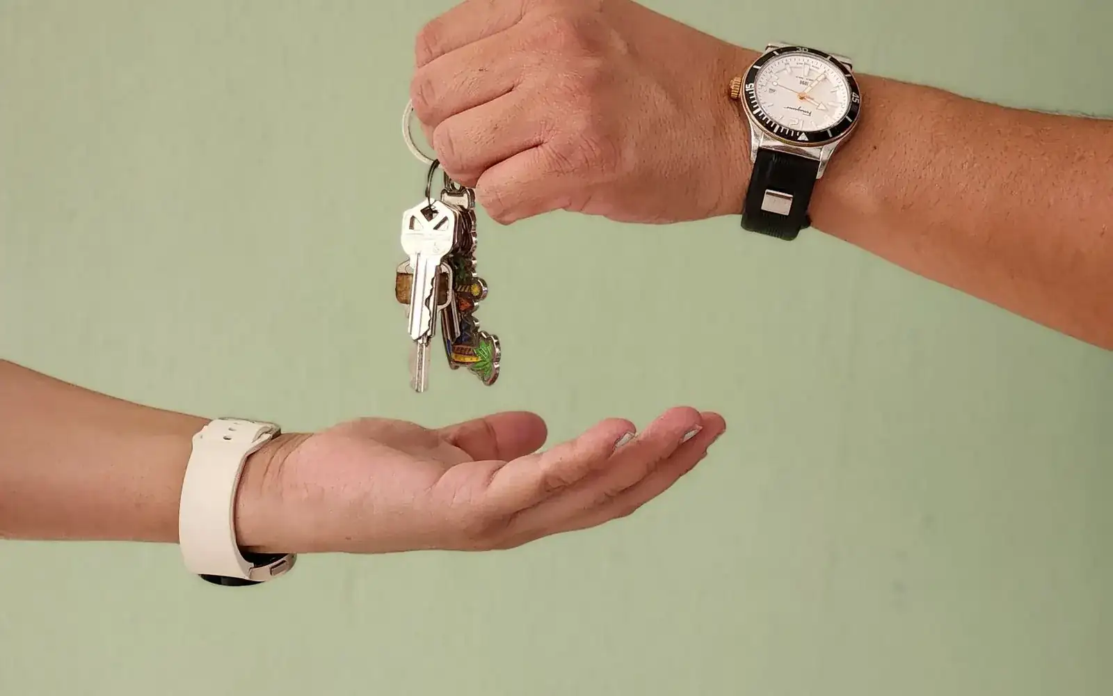 A set of car keys handed down into an open palm